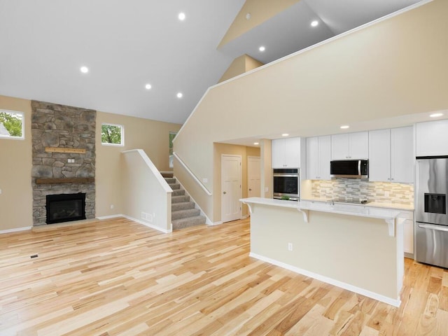 17394 Sunset Trl SW, Prior Lake, MN 55372 - kitchen featuring appliances with stainless steel finishes, light countertops, an island with sink, a kitchen bar, and white cabinets