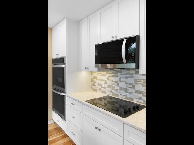 17394 Sunset Trl SW, Prior Lake, MN 55372 - kitchen with appliances with stainless steel finishes, decorative backsplash, white cabinetry, light stone counters, and light wood-type flooring