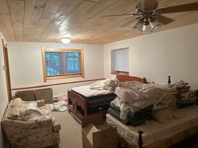 bedroom with wood ceiling and carpet