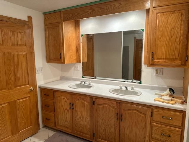 bathroom with double vanity and tile patterned flooring