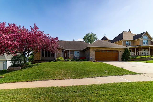 view of front of property with an attached garage, driveway, a front lawn, and brick siding