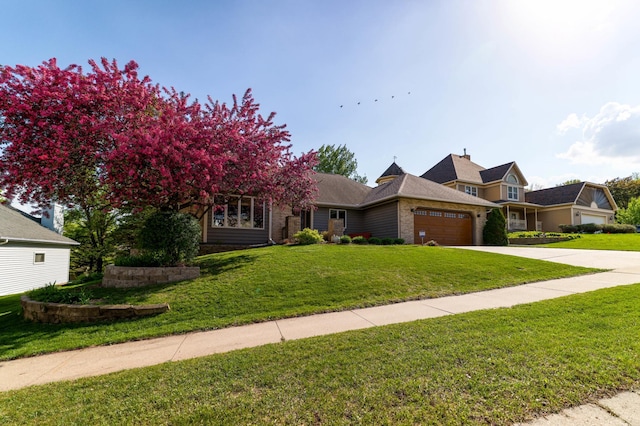 view of front facade with a garage, a front yard, concrete driveway, and brick siding