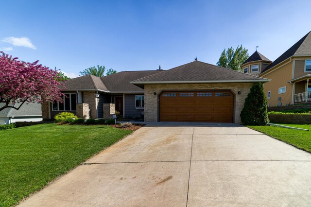 view of front facade featuring concrete driveway, an attached garage, brick siding, and a front lawn