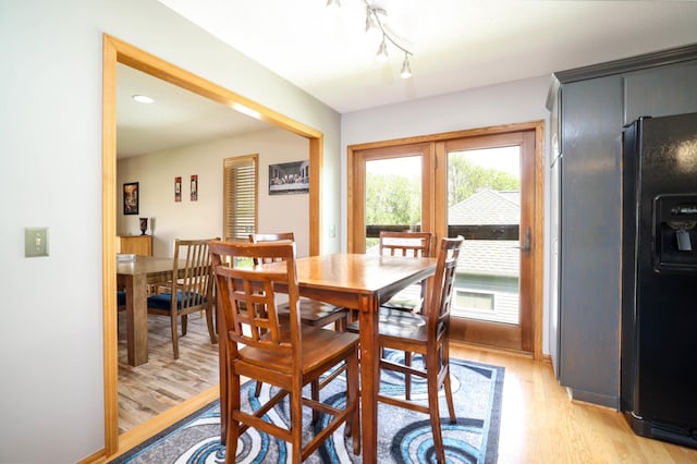 dining room with light wood-style floors and track lighting
