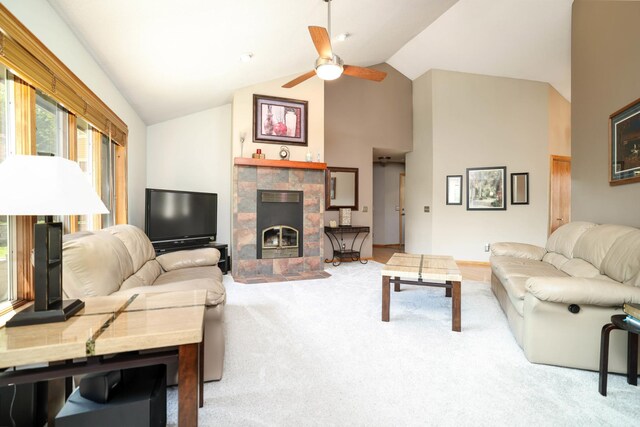 living area featuring carpet floors, ceiling fan, a tile fireplace, and high vaulted ceiling