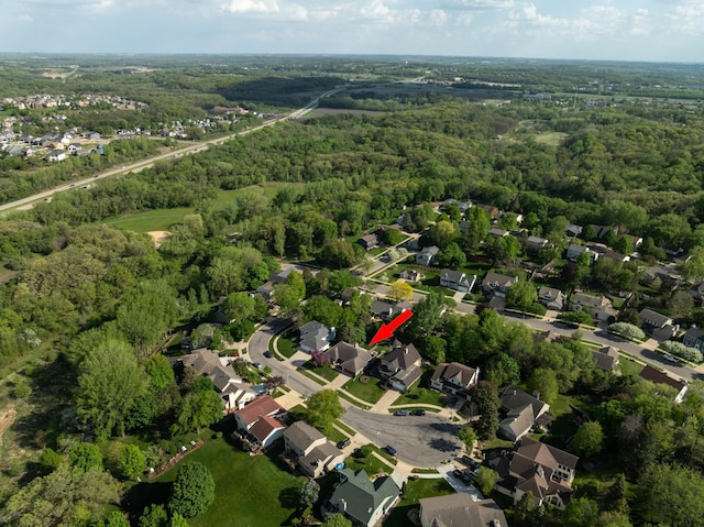 aerial view of property's location with a forest and nearby suburban area