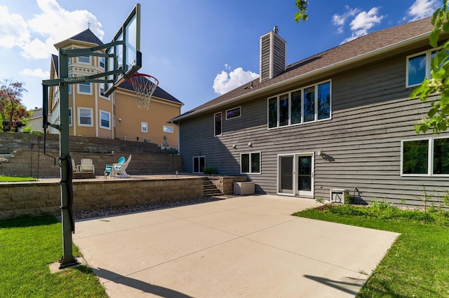 back of property featuring a chimney, a patio area, and fence