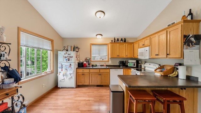 833 19th Ave N, Saint Cloud, MN 56303 - kitchen featuring white appliances, lofted ceiling, dark countertops, a peninsula, and light wood finished floors