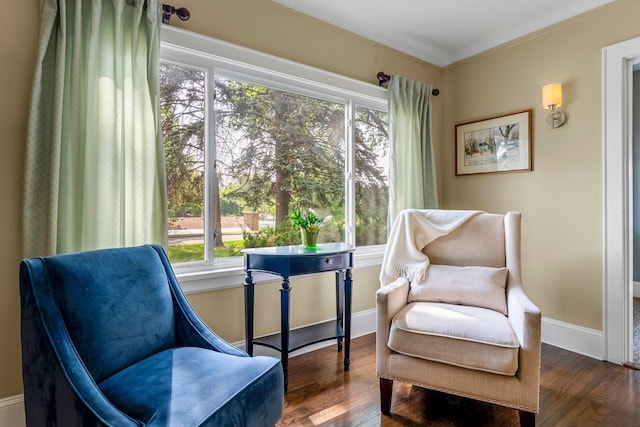 living area featuring healthy amount of natural light, hardwood / wood-style floors, and baseboards
