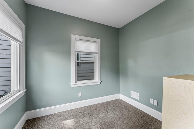 carpeted empty room with baseboards