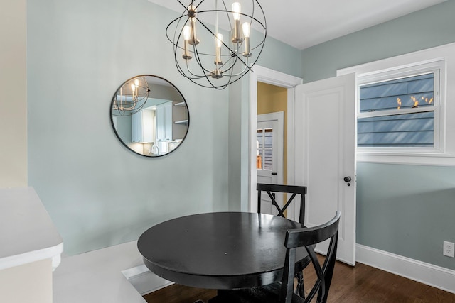 dining space featuring a chandelier, dark wood-style floors, and baseboards
