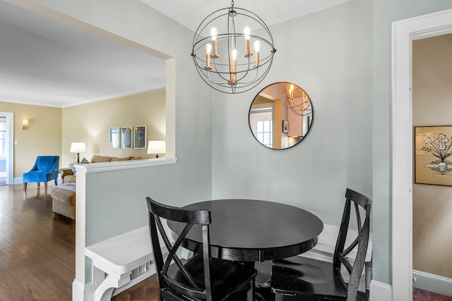 dining room featuring a chandelier, baseboards, and wood finished floors
