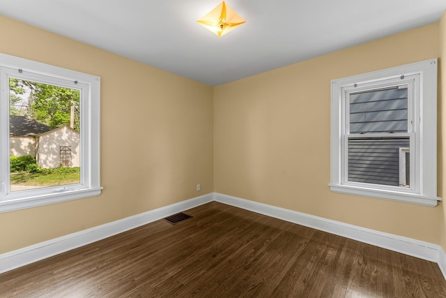 unfurnished room with dark wood-style floors and baseboards