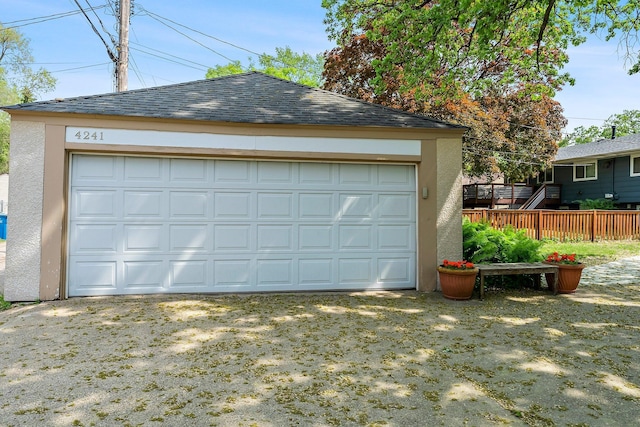 detached garage featuring fence