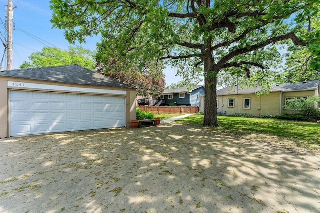 view of yard with fence, an outdoor structure, and a garage