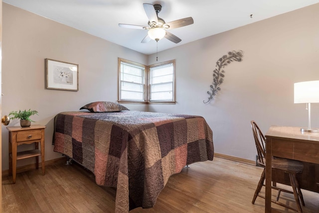 bedroom featuring wood finished floors, baseboards, and ceiling fan