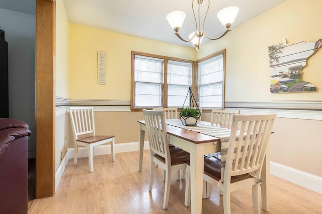 dining area with wood finished floors, a chandelier, and baseboards