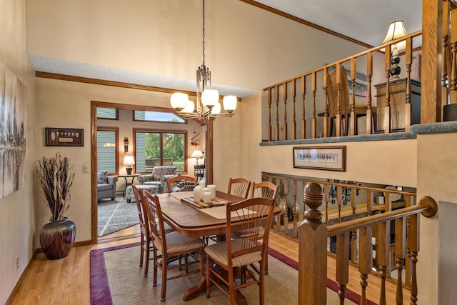 480 Suzanne Ave, Shoreview, MN 55126 - dining room with a towering ceiling, wood finished floors, a chandelier, crown molding, and baseboards