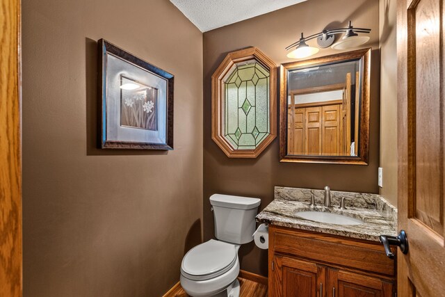 480 Suzanne Ave, Shoreview, MN 55126 - bathroom with toilet, vanity, baseboards, and wood finished floors