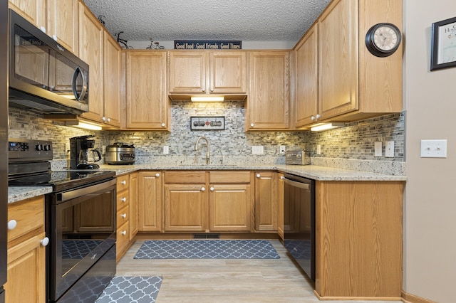 20446 Cypress Dr, Farmington, MN 55024 - kitchen featuring appliances with stainless steel finishes, a sink, light wood-style floors, light stone countertops, and backsplash