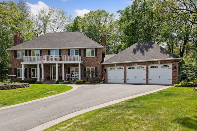 1438 Kings Wood Rd, Eagan, MN 55122 - view of front facade featuring a chimney, asphalt driveway, an attached garage, a front yard, and a balcony