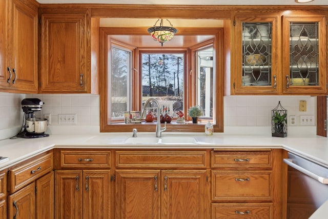 1438 Kings Wood Rd, Eagan, MN 55122 - kitchen with stainless steel dishwasher, a sink, brown cabinets, and light countertops