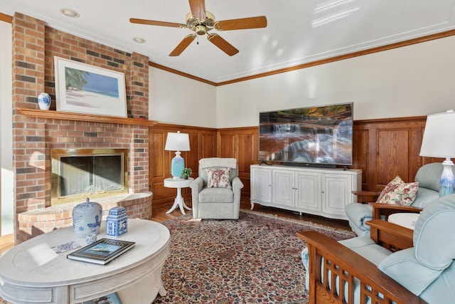 1438 Kings Wood Rd, Eagan, MN 55122 - living area featuring ornamental molding, wainscoting, a ceiling fan, wood finished floors, and a brick fireplace
