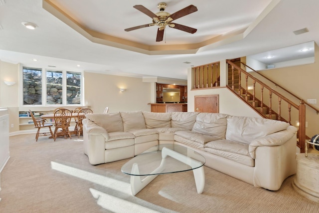 1438 Kings Wood Rd, Eagan, MN 55122 - living room featuring ceiling fan, stairs, a tray ceiling, and light carpet