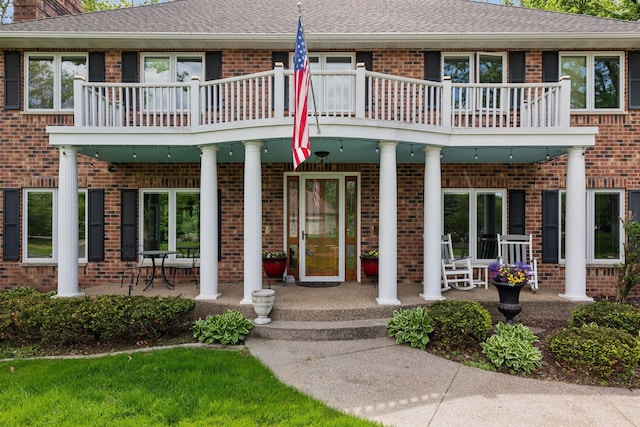 1438 Kings Wood Rd, Eagan, MN 55122 - property entrance with brick siding, a porch, a balcony, and a shingled roof