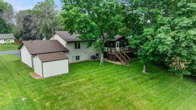 824 96th Ln NE, Blaine, MN 55434 - rear view of house with stairway, a deck, a shingled roof, a storage unit, and a lawn
