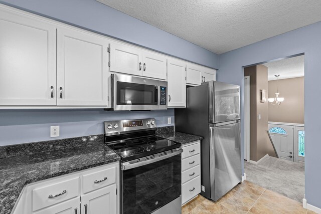 824 96th Ln NE, Blaine, MN 55434 - kitchen with stainless steel appliances, white cabinetry, a textured ceiling, a chandelier, and dark stone countertops