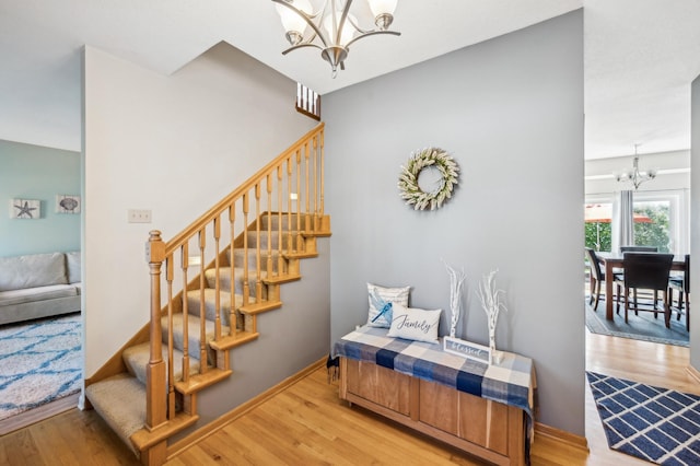 1005 Hope Ave, Jordan, MN 55352 - stairs with a chandelier, wood finished floors, and baseboards