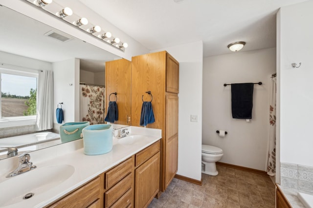1005 Hope Ave, Jordan, MN 55352 - full bathroom featuring toilet, double vanity, a bath, and baseboards