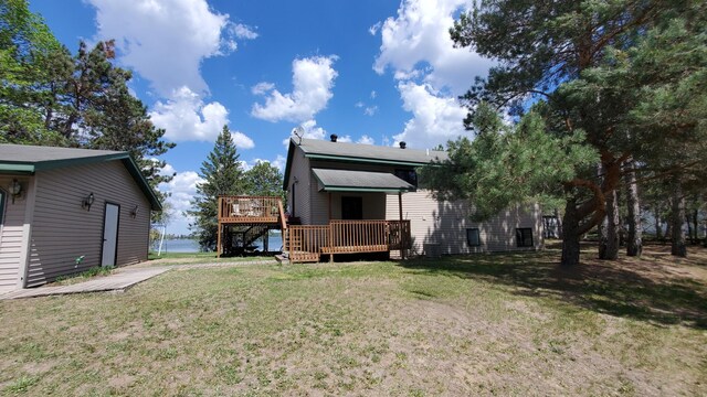 rear view of property featuring a deck and a lawn