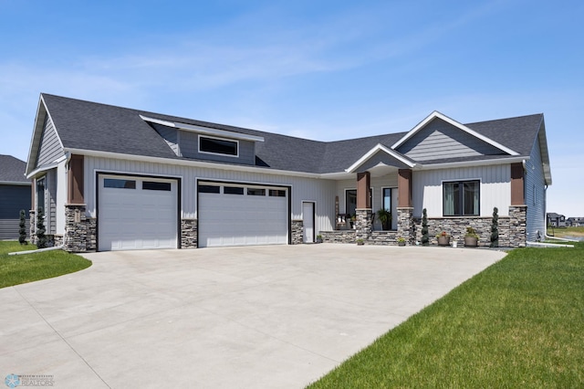 1991 69th Ave S, Fargo, ND 58104 - view of front of house with stone siding, an attached garage, driveway, and a shingled roof