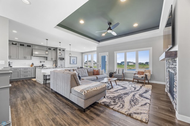 1991 69th Ave S, Fargo, ND 58104 - living room with a raised ceiling, ceiling fan, recessed lighting, dark wood-style flooring, and baseboards