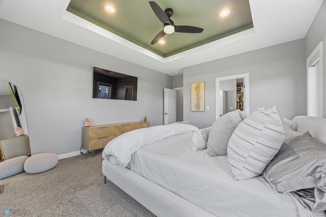 1991 69th Ave S, Fargo, ND 58104 - carpeted bedroom featuring a tray ceiling, a spacious closet, baseboards, recessed lighting, and ceiling fan
