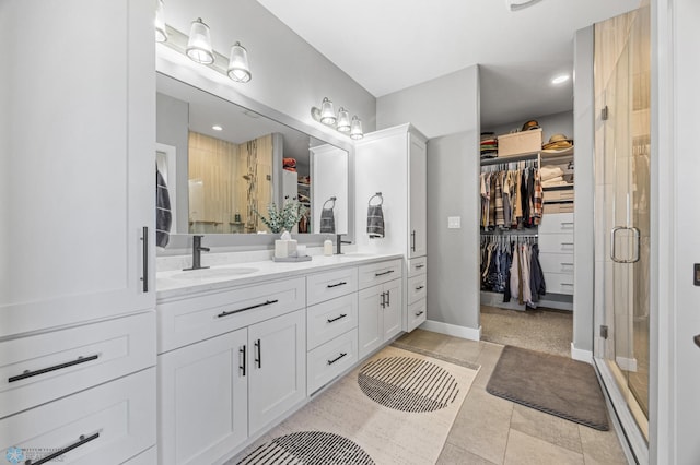 1991 69th Ave S, Fargo, ND 58104 - bathroom with a walk in closet, double vanity, a stall shower, baseboards, and recessed lighting