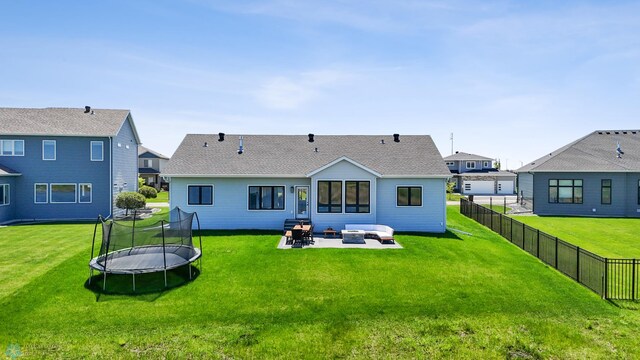 1991 69th Ave S, Fargo, ND 58104 - rear view of property with a patio, a trampoline, a shingled roof, and an outdoor living space with a fire pit