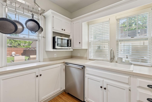 3313 Yosemite Ave S, Saint Louis Park, MN 55416 - kitchen with stainless steel appliances, a sink, white cabinetry, and light countertops