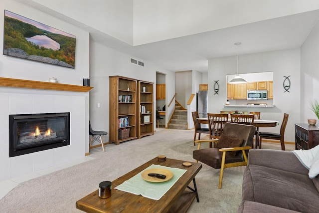 12977 Echo Ln, Apple Valley, MN 55124 - living room with light colored carpet, a tiled fireplace, stairs, and baseboards