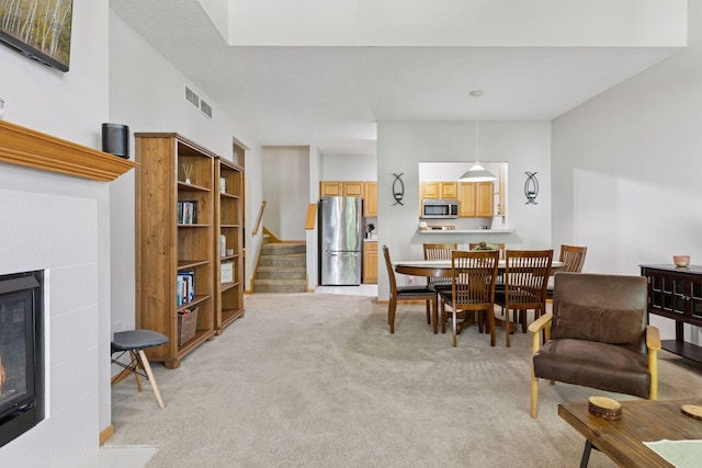 12977 Echo Ln, Apple Valley, MN 55124 - dining room featuring light carpet, a tile fireplace, and stairs