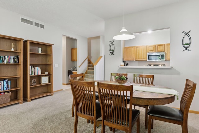 12977 Echo Ln, Apple Valley, MN 55124 - dining space featuring light carpet, stairway, and baseboards