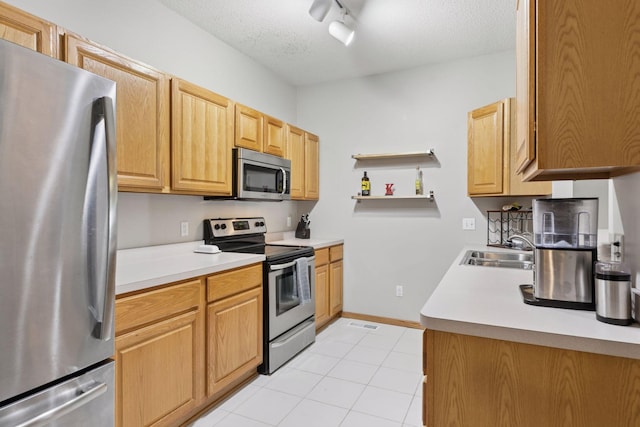 12977 Echo Ln, Apple Valley, MN 55124 - kitchen with appliances with stainless steel finishes, a sink, open shelves, light tile patterned floors, and a textured ceiling