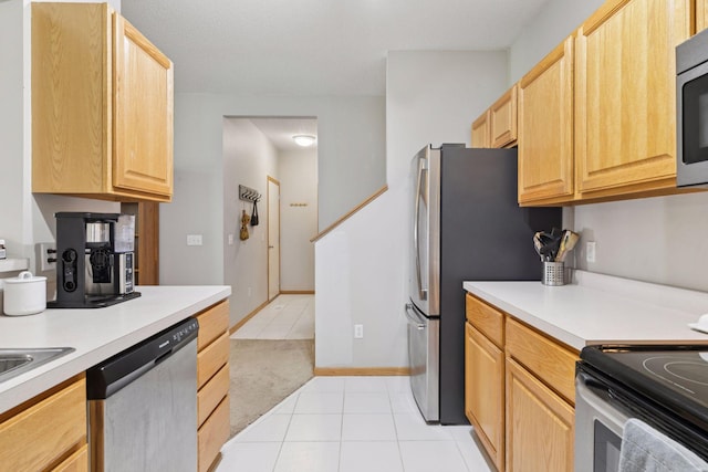 12977 Echo Ln, Apple Valley, MN 55124 - kitchen with stainless steel appliances, light brown cabinetry, light tile patterned floors, and light countertops