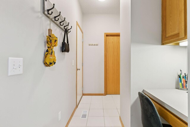 12977 Echo Ln, Apple Valley, MN 55124 - hall featuring light tile patterned flooring, a desk, and baseboards