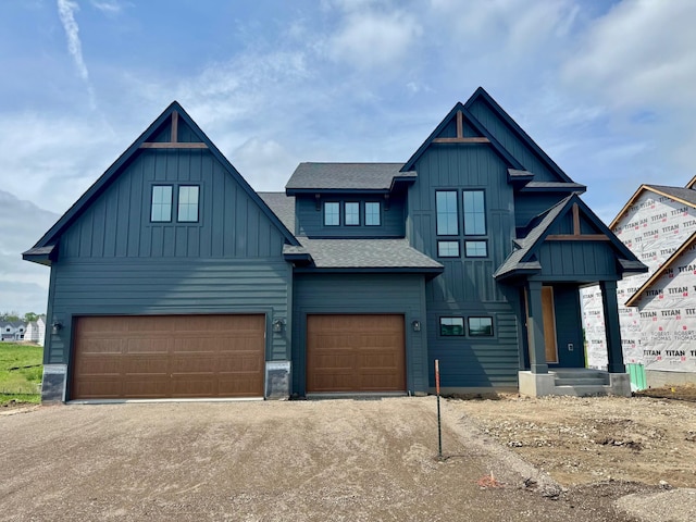 17970 103rd Ave N, Maple Grove, MN 55311 - view of front of house with board and batten siding, a garage, a shingled roof, and driveway