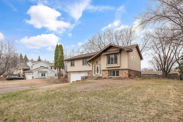 raised ranch featuring brick siding and a garage