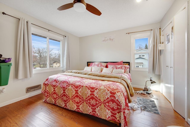 bedroom with wood finished floors, baseboards, and a ceiling fan