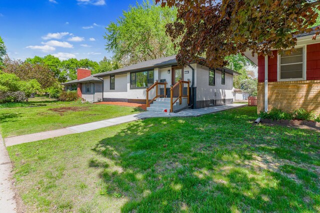 single story home with a chimney, brick siding, and a front lawn